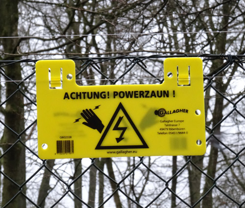 Hinweisschild "Achtung! Powerzaun!" an der Freianlage für Mandschurenkraniche Ende Januar 2016 im Grünen Zoo Wuppertal